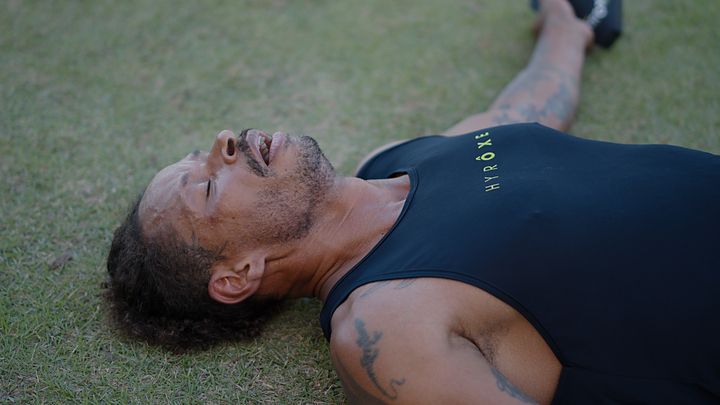 Atleta deitado na grama após a chegada