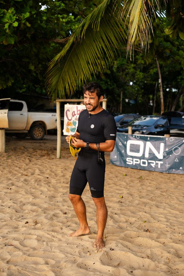 Atleta sorrindo ao lado do banner ON SPORT