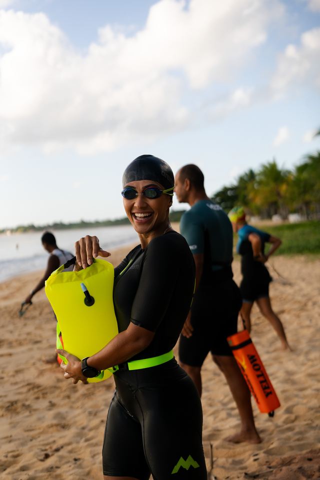 Triatleta sorrindo com a boia de natação