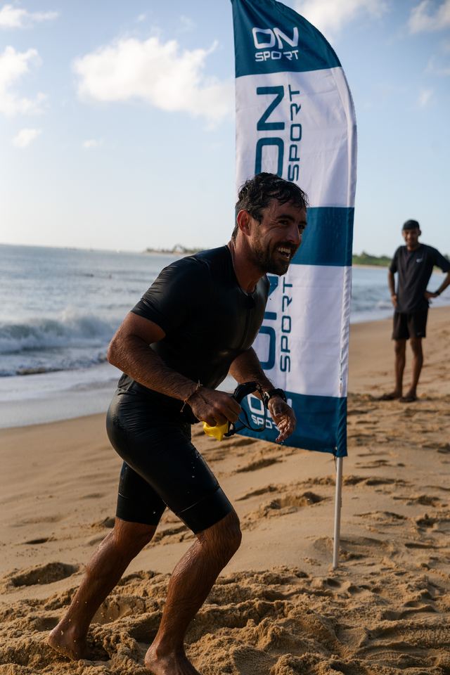 Saída da natação: atleta sorrindo na areia