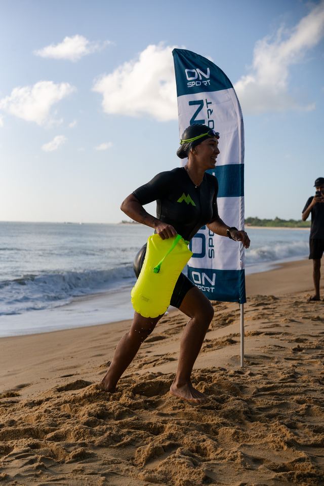 Triatleta saindo do mar com a boia