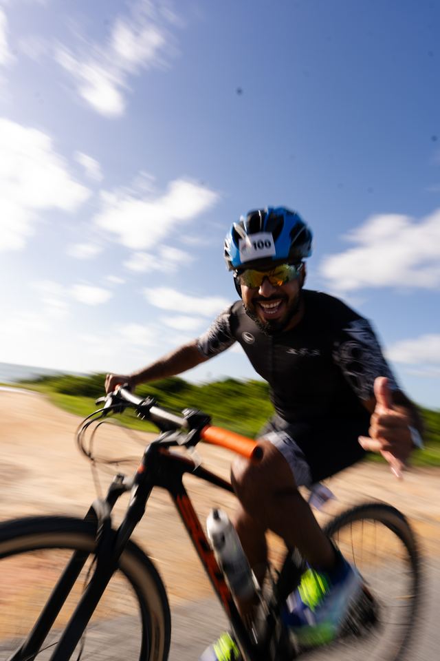 Ciclista sorrindo e acenando durante o pedal
