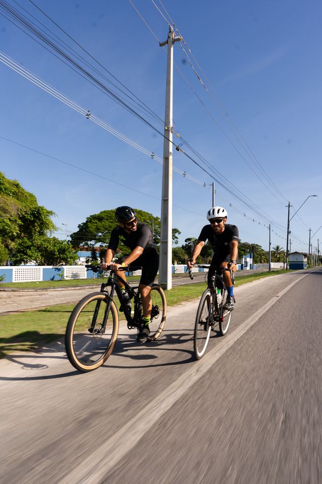 Dupla de ciclistas pedalando pela vila