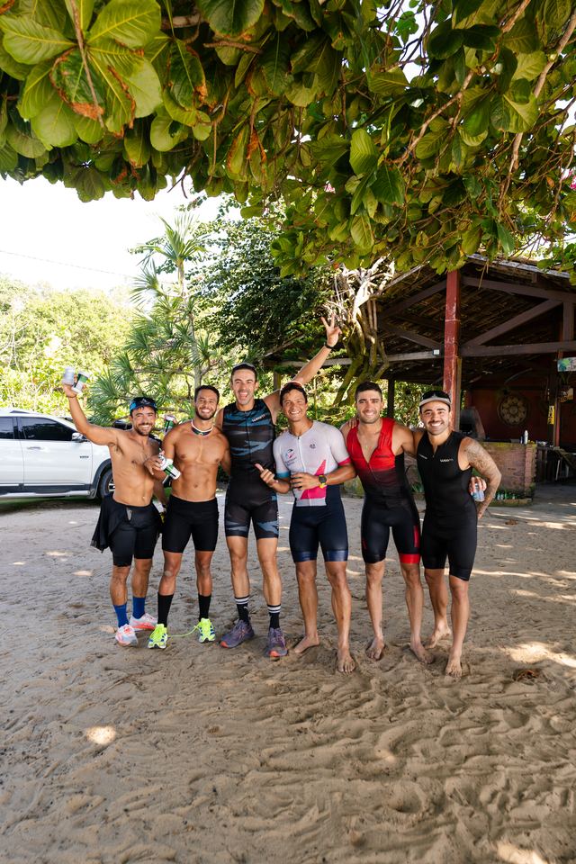 Grupo de atletas posando na areia