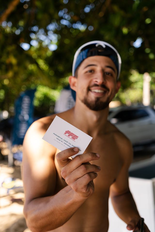 Atleta mostrando o cartão do brinde