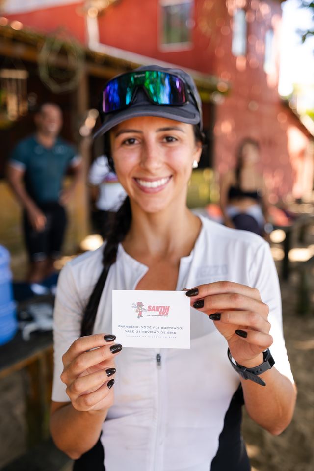 Atleta sorridente com o cartão do brinde